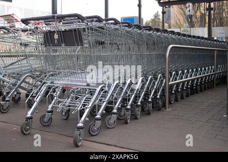 Metal grocery carts stand in a store parking bay Stock Photo