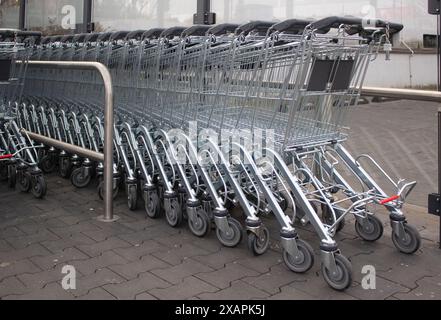 Metal grocery carts stand in a store parking bay Stock Photo