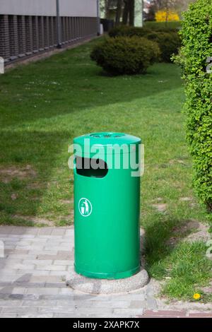 Public trash can on a city street filled with garbage Stock Photo