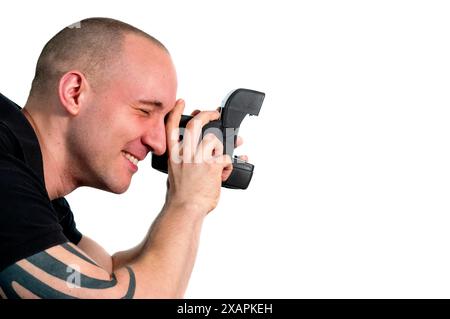 Head and shoulder portrait of a young man with instant camera in profile isolated on white. Stock Photo