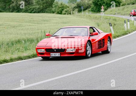 Red Ferrari sports car driving on a country road in a natural environment, classic car, car racing, Mille Miglia, 1000 Miglia, Tuscany, Rome, Lake Stock Photo