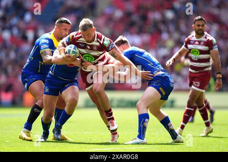 Wigan Warriors' Mike Cooper is tackled by Warrington Wolves' Rodrick Tai and Ben Currie during the Betfred Challenge Cup final at Wembley Stadium, London. Picture date: Saturday June 8, 2024. Stock Photo