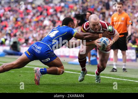 Wigan Warriors' Liam Marshall (right) is tackled by Warrington Wolves' Rodrick Tai (left) before the try-line during the Betfred Challenge Cup final at Wembley Stadium, London. Picture date: Saturday June 8, 2024. Stock Photo