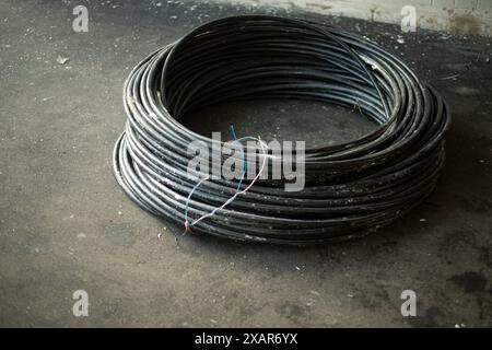 Rolled cable. Wire on the street. Repair work. An electrical cable lies on the asphalt. Stock Photo