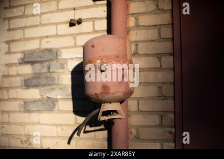 Gas cylinder. Gas barrel in the garage. Pipe on the wall. Details of the building. Stock Photo