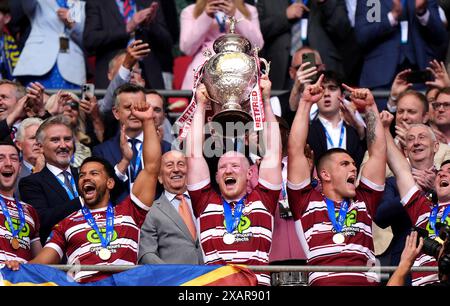 Wigan Warriors' Liam Farrell (centre) lifts the trophy with team-mates ...