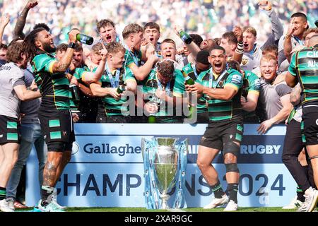 Northampton Saints players celebrate on the pitch with the trophy after winning the Gallagher Premiership final at Twickenham Stadium, London. Picture date: Saturday June 8, 2024. Stock Photo