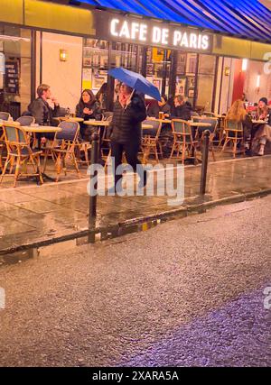 Pedestrian with umbrella in rainy Paris Stock Photo - Alamy