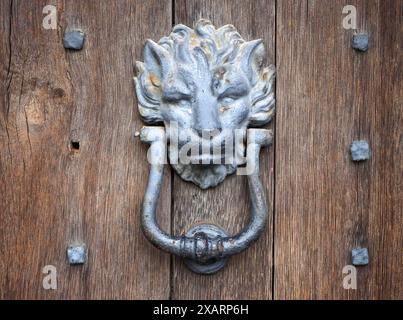 Antique Lion Door Knocker on a Studded Wooden Door Stock Photo
