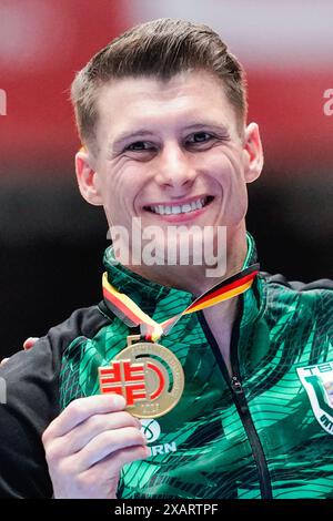 08 June 2024, Hesse, Frankfurt/Main: Gymnastics: German Championships, all-around, men, Süwag Energie Arena. The winner Lukas Dauser holds his medals in his hands. Photo: Uwe Anspach/dpa Stock Photo