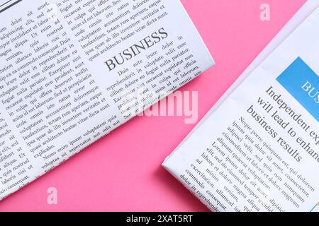 Different newspapers on pink background Stock Photo