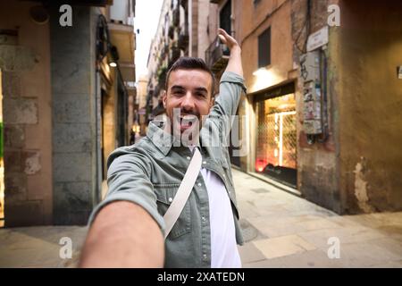 Young excited Caucasian man taking selfie on Paris touristic city street in background.  Stock Photo