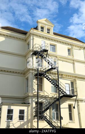 A metal fire escape staircase on the side of a building in Eastbourne, East Sussex., England, UK.  fire escapes safety stairs buildings Stock Photo