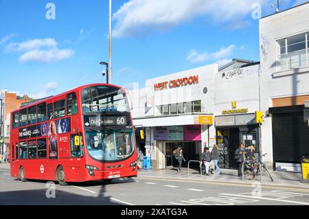 Red double decker bus passing West Croydon London Overground rail / train station Zone 5, London Borough of Croydon, South London UK. Public transport Stock Photo