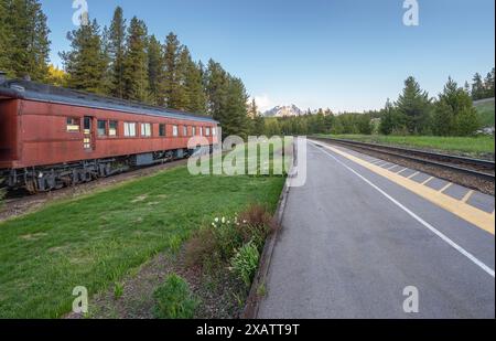 Train tracks and historic passenger train car at the Lake Louise Train Station in Banff National Park, Alberta, Canada Stock Photo