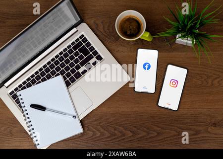 Facebook and instagram app on two mobile phones screen over a desk. Top view, flat lay. Rosario, Argentina - June 06, 2024. Stock Photo