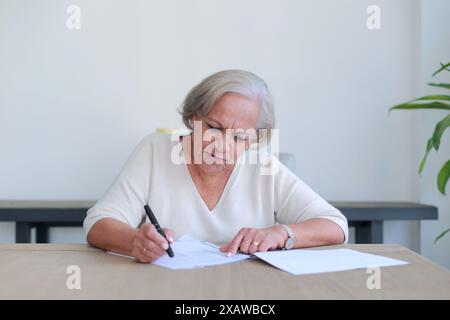 Thoughtful lady reviews important documents at home Stock Photo