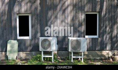 Powerful air conditioners installed on the wall of a wooden rural   barn Stock Photo