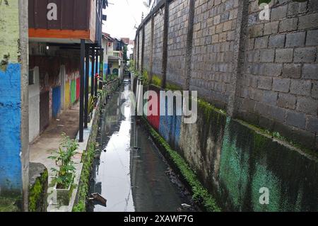 A fairly large water drainage channel crosses dense residential areas in the city of Bandung, West Java, Indonesia Stock Photo