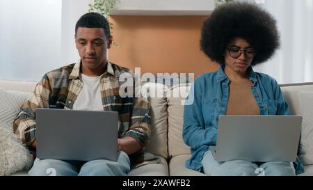 African American woman work with laptop man job online with computer couple two freelancers working at home couple with two pc computers coworking at Stock Photo