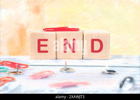 The end sign on wooden cubes on a yellow background Stock Photo