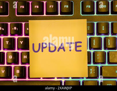 Business concept. UPDATE text on a yellow sticker lying on the keyboard with a colored backlight Stock Photo