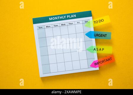 White monthly plan on a yellow background with bright colored sticky notes for organization Stock Photo