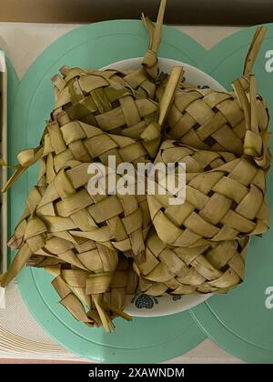 Photo of puso , tamu, also known in Philippine English as hanging rice, a Filipino steamed rice cooked and wrapped in palm or coconut leaves. Stock Photo