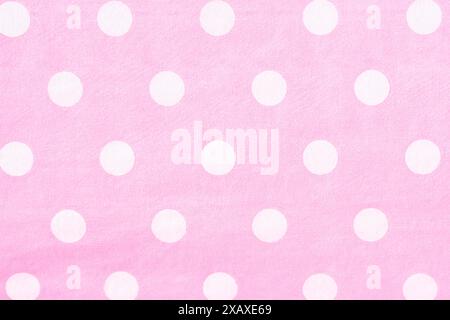 Close up shot of the texture of a pink paper with white polka dots. Use as backgrounds, wallpapers and textures. Horizontal. Stock Photo
