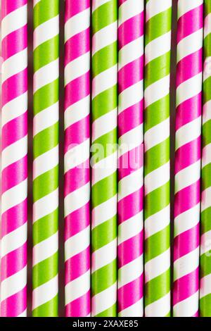 Sustainable and ecological straws made of cardboard in fuchsia and green color placed in a row. Directly above shot. Directly above shot. Stock Photo
