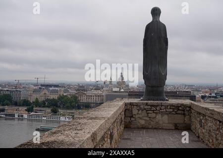 Virgin Mary Statue looking out from Buda Castle Hill over the River Danube, Budapest, Hungary. In the distance you can see St. Stephen's Basilica. Stock Photo