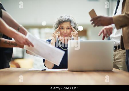 Confused, chaos and business woman in office with documents, report and admin crisis on computer. Mature manager or CEO headache or thinking of Stock Photo