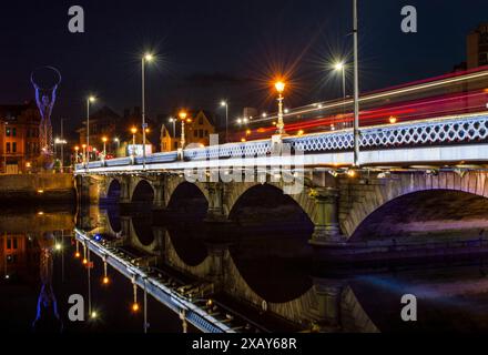 Belfast, UK, August 11, 2020. Belfast Queen's Bridge in the night with colorful lights reflection on River Lagan. Stock Photo