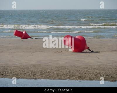 Two Red Buoys Lie On A Deserted Sandy Beach Overlooking The Sea, De 