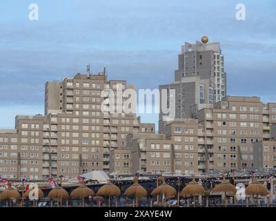 Modern skyscrapers against a blue sky, in the foreground cap roofs of beach bars, scheveningen, the netherlands Stock Photo