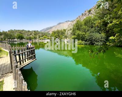 Tourist Holidaymaker standing on small viewing platform looking at artificial lake created in 1987 on the edge of the Psiloritis Mountains, fed by Stock Photo
