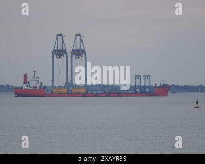 Sheerness, Kent, UK. 9th June, 2024. Heavy lift vessel Zhen Hua 36 seen carrying two quay cranes (which to the layman would appear precariously balanced) as it departs the Thames after having arrived with 4 cranes and dropped two cranes off at London Gateway earlier in the week. Credit: James Bell/Alamy Live News Stock Photo