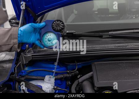 Car winter maintenance antifreeze control. Automobile mechanic tests car antifreeze liquid for winter and summer. Car wiper fluid controls and adding Stock Photo