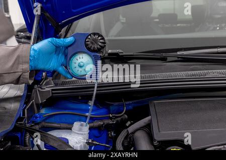 Car winter maintenance antifreeze control. Automobile mechanic tests car antifreeze liquid for winter and summer. Car wiper fluid controls and adding Stock Photo