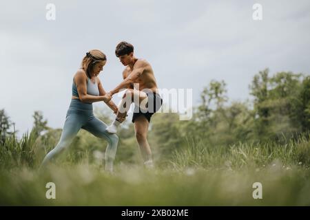 Couple engaging in fitness exercises in the park on a sunny day Stock Photo