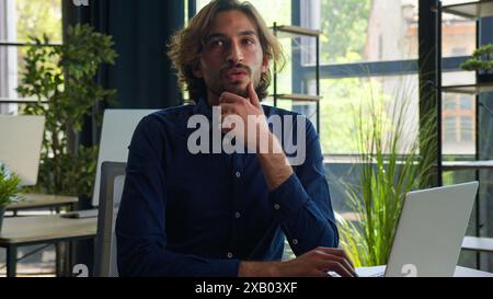 Thoughtful Arabian businessman pensive puzzled office worker male employer business manager CEO doubtful ethnic man working with laptop computer think Stock Photo