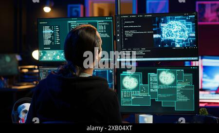 Hacker drinking coffee while running artificial intelligence spyware software designed to gather information from users. Script kiddie doing illegal stuff using AI, consuming beverage, camera A Stock Photo
