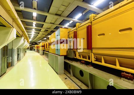 Vintage experimental equipment of hadron collider in long lit corridor. Old industrial facility with technology for physics tests in empty enclosure Stock Photo