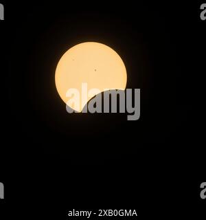 The beginning of the total solar eclipse as the moon moves across the sun and begins to cover the sun. Stock Photo