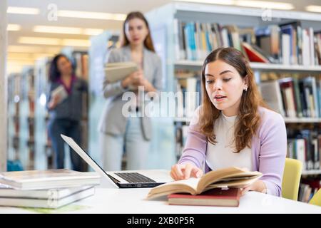 Young woman working on laptop at library Stock Photo