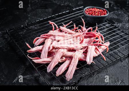 Raw Duck Tongue ready for cooking. Black background. Top view. Stock Photo