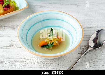 Fish soup with vegetables on white wooden table Stock Photo