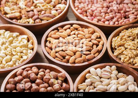 bowls of various mixed nuts on wooden table Stock Photo