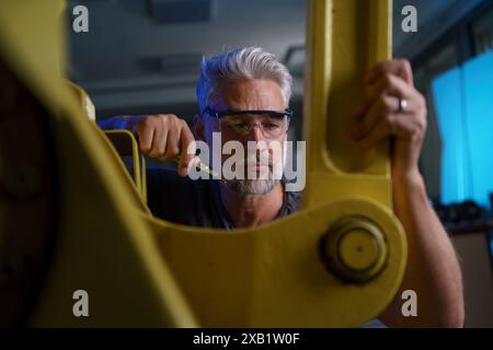 Automation engineer checking, servicing robotic arm. Concept of modern technology in industries, automated processes, robotics. Stock Photo