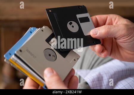 mature male hand holding vintage electronic data storage devices Collection from 80s, 90s, disk, flash drives, Nostalgia for Technology, rapid advance Stock Photo